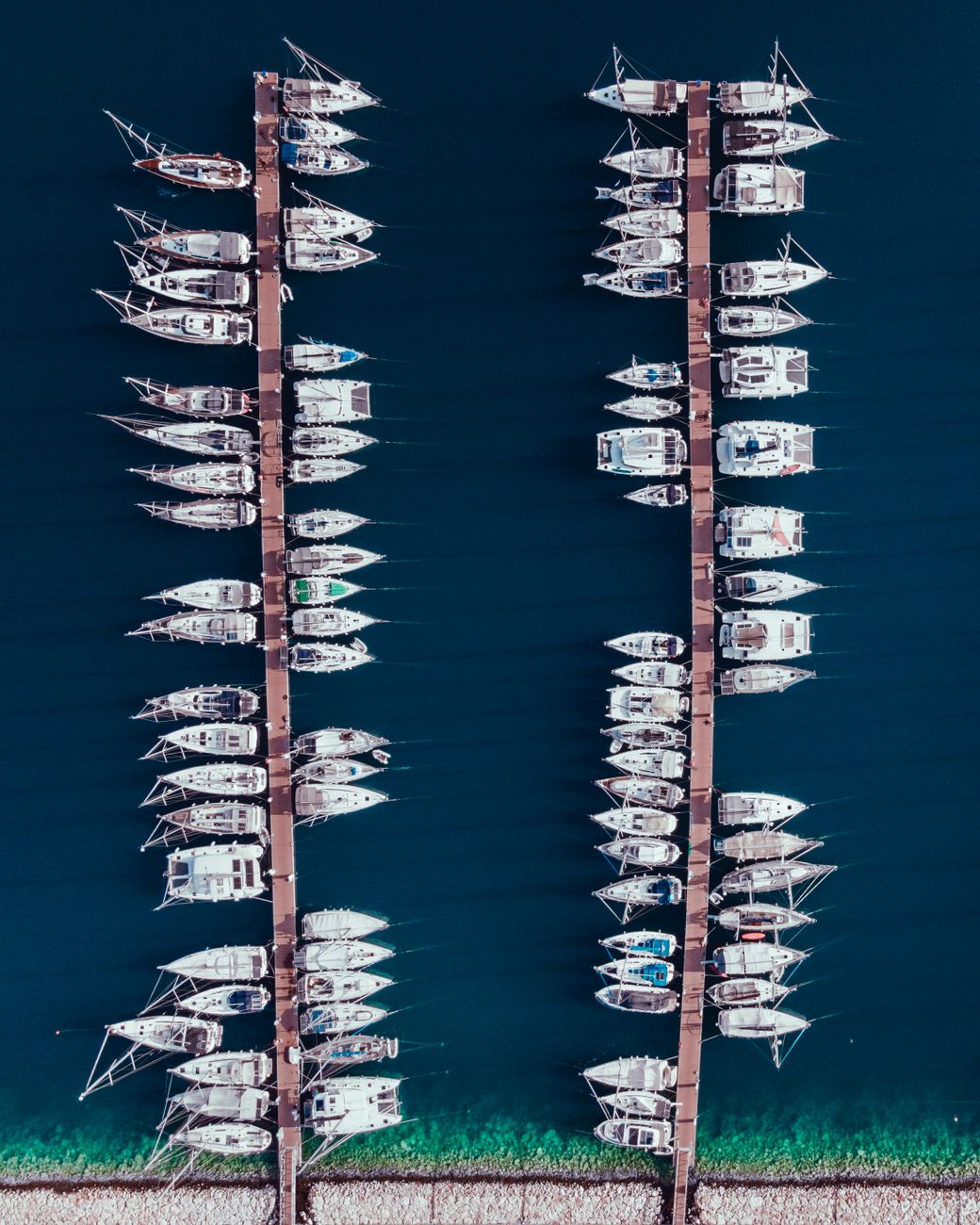Stunning aerial view of boats neatly docked at a serene marina.