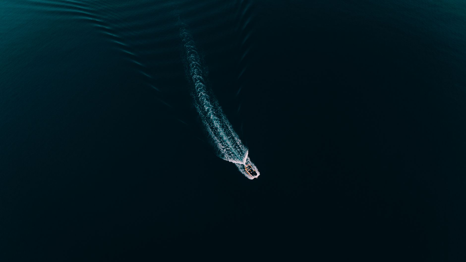 Aerial shot of a speedboat creating ripples on the calm blue waters in Demre, Antalya.